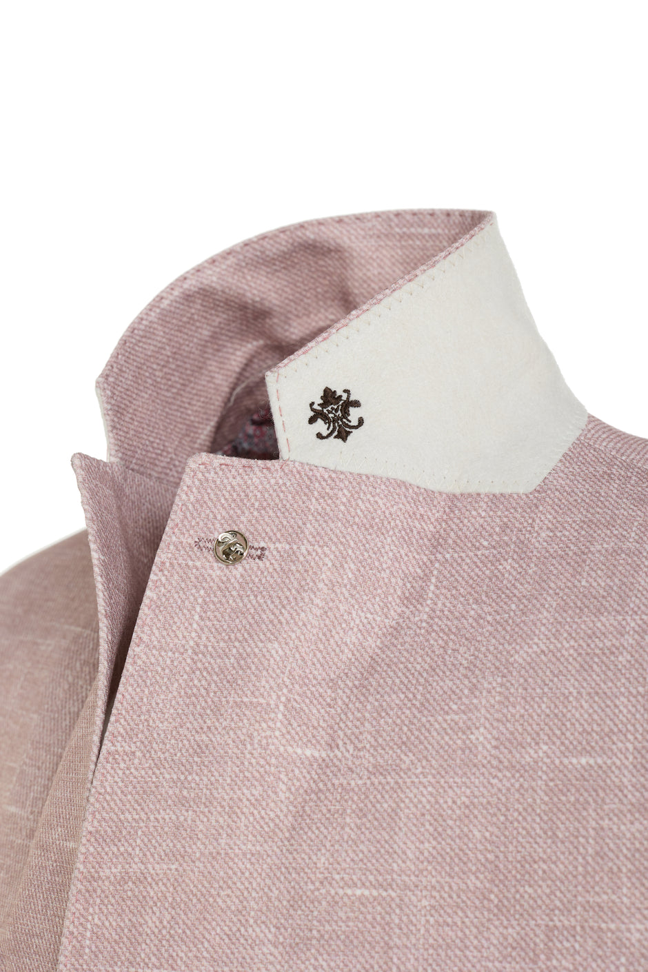 Close-up of a pink textured shirt collar with a white inner lining and a small logo.